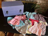overall view showing purple chest and all doll clothes laid out