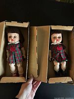 Two Littlest Angel dolls lying in their original cardboard boxes