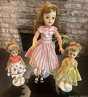 Three Miss Revlon dolls standing on display bases showing size and outfits