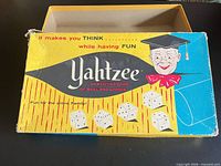 Top view of Yahtzee box lid with graphics, lid partially open