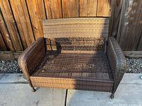 Front view of brown wicker loveseat frame showing full structure
