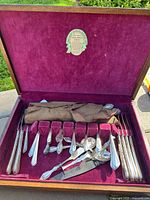 open wooden flatware case showing utensils in slots