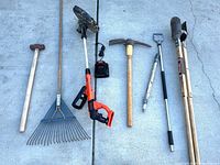 All six garden tools laid out on concrete