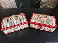 Top view of both wicker sewing boxes showing handles, red trim, latches, and lid details