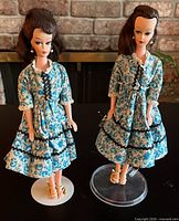 Two Wendy fashion dolls in matching blue floral dresses on stands