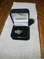 Ring in black velvet case on fabric background