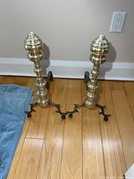 Front view of both brass andirons showing full height and design