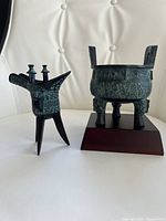 Front view of both bronze replicas—ding on stand, jue freestanding