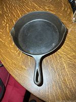 Top view of entire cast iron frying pan on wooden surface