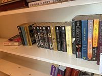 Full view of shelf showing entire row of paperbacks grouped by author