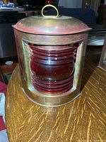 Front view of brass lantern with red Fresnel lens