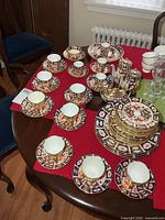 Overhead view showing majority of cups, saucers, plates, cocoa pots and sugar dish