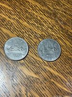 Both 1972 and 1975 Canada silver dollar coins reverse side showing Voyageur canoe