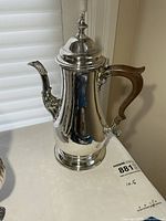Full view of sterling coffee pot showing lid, spout and wooden handle