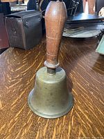 Overall view of brass bell and wooden handle