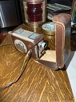 Camera in open leather case on table
