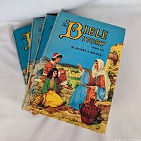 Stack of four The Bible Story volumes showing cover art of volume 1