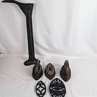 Full lot showing cobbler stand, three irons, two trivets