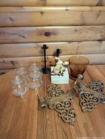 All items grouped on tabletop: sconces, glassware, vase, cats on bone box, candleholders