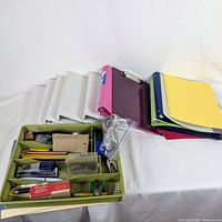 Overview of binders, report covers and desk organizer tray with office supplies