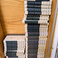Stack of World Book Year Book and Science Year volumes on shelf