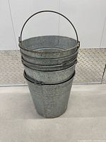 Front view of stacked galvanized buckets