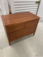 Front view showing three drawers with metal knobs