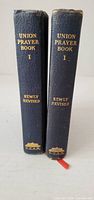 Two standing hardcover prayer books showing spine titles