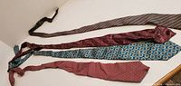 Four ties laid out flat showing length and patterns