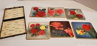 All six rose design coasters with open storage case interior