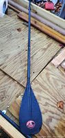 Full view of black Adventure Technology paddle on wooden surface