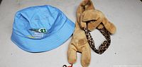 Blue NJ Lottery bucket hat and tan plush dog toy displayed on flat surface