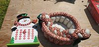 Snowman countdown calendar and braided fabric basket side by side on table