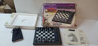All contents laid out: chess board, pieces, pouch, tray, manuals, box