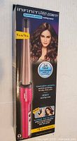 Front view of sealed retail box showing pink InfinitiPRO by Conair curling wand and product details