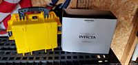 Yellow Invicta case next to cardboard sleeve