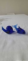 front view of cobalt blue glass snail and dolphin figurines