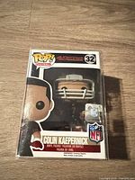 Front view of boxed Funko Pop Colin Kaepernick figure showing window, Pop! Football logo, NFL hologram