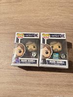 Front view of both boxed figures showing numbers 27 and 28, exclusive stickers and shrink wrap