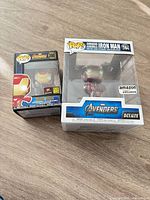 Front view of both boxed Iron Man Funko Pop! figures (#380 standard, #584 Deluxe)