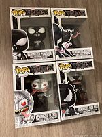 Front view of four boxed Funko Pop Venomized figures