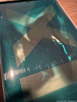 Teal plastic box lid with large X cut-out for Air Jordan 11 packaging