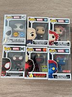 Front view of six boxed Funko Pop! Marvel figures showing character art, numbers and exclusive stickers