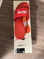 Top view of red slide on Nike box with Stussy strap logo