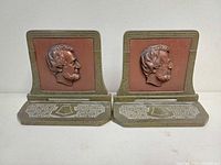 Front view of pair showing Lincoln profiles and decorative bases