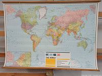 Front view of entire world map on wall with wooden dowels