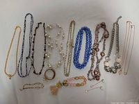 All thirteen jewelry pieces laid out on white background