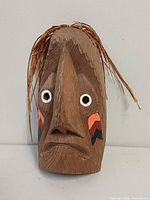 front view showing carved features, paint and straw hair