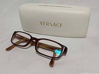 Eyeglasses front view resting on Versace case