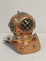 Front view of copper and brass miniature diving helmet showing lattice windows